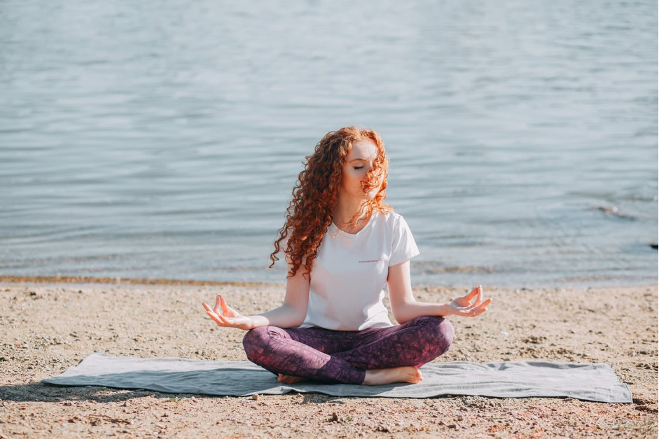 Woman Doing Yoga Exercise At The Sea Shore