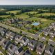 Aerial view of suburban homes and new construction illustrating real estate growth and community trends